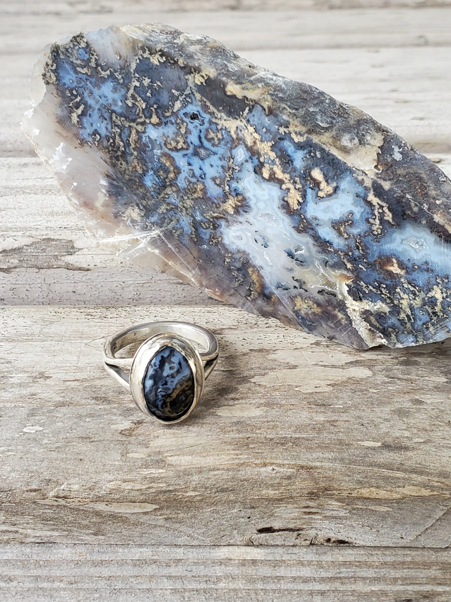 Oval Blue and Gold Agate Cabochon Sterling Silver Split Ring shown against agate slab it was cut from
