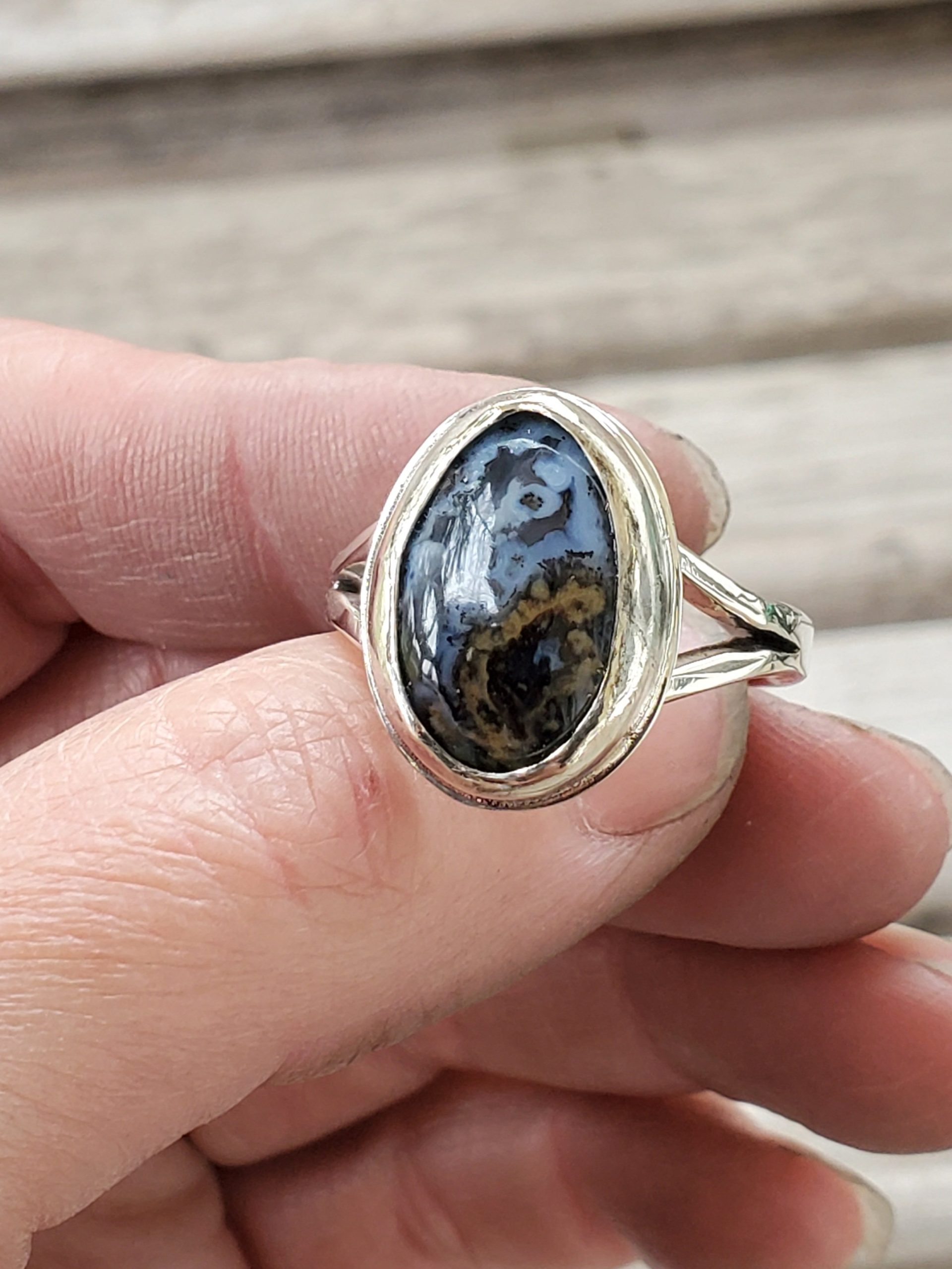 Oval Blue and Gold Agate Cabochon Sterling Silver Split Ring shown in model's hand