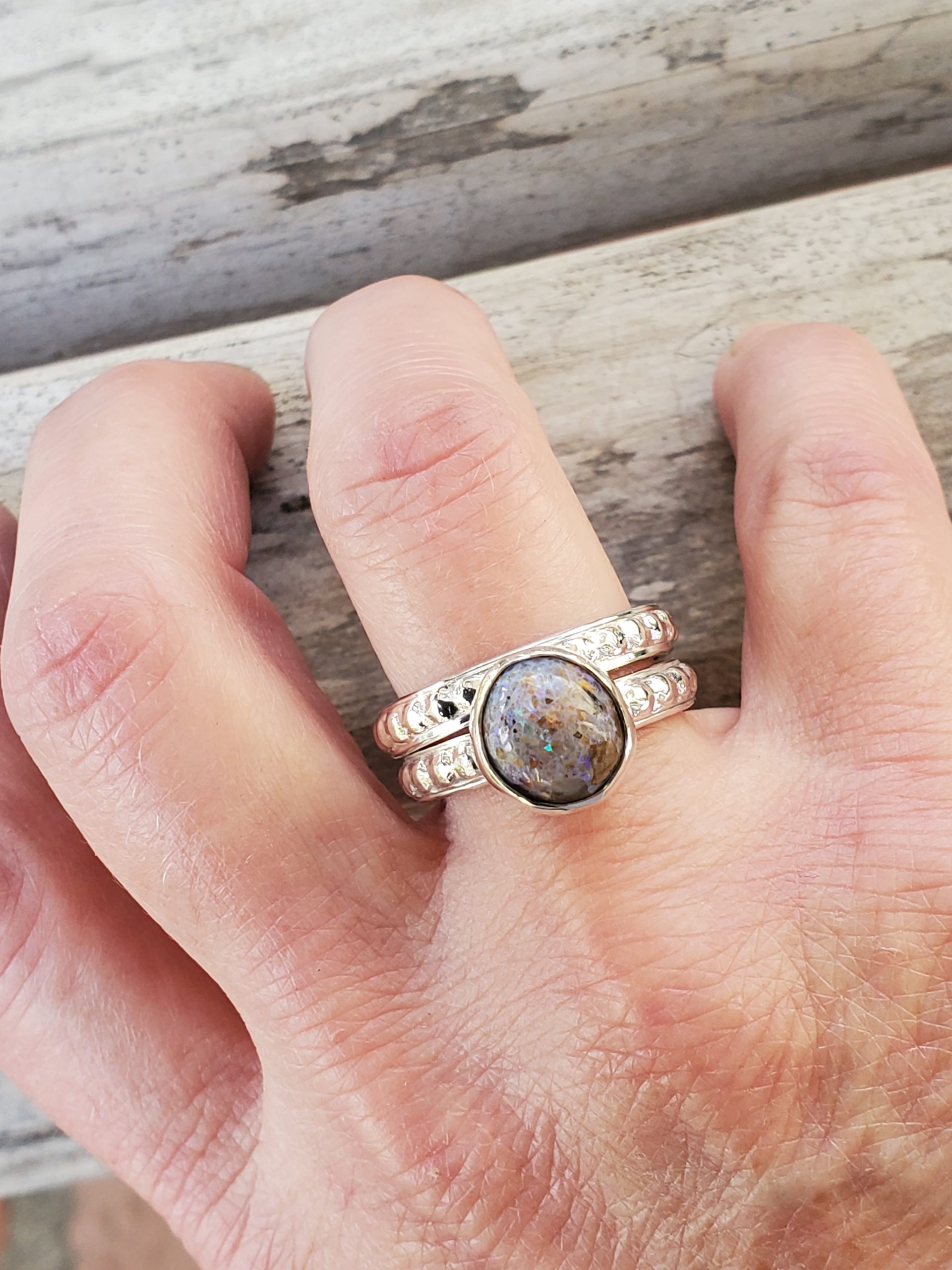 Round Louisiana Opal Cabochon Sterling Silver Textured Ring shown with second band on model's ring finger