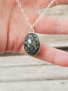 Oval Gray Agate Cabochon Sterling Silver Chain Necklace held in model's hand