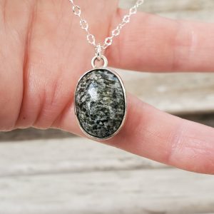 Oval Gray Agate Cabochon Sterling Silver Chain Necklace held in model's hand