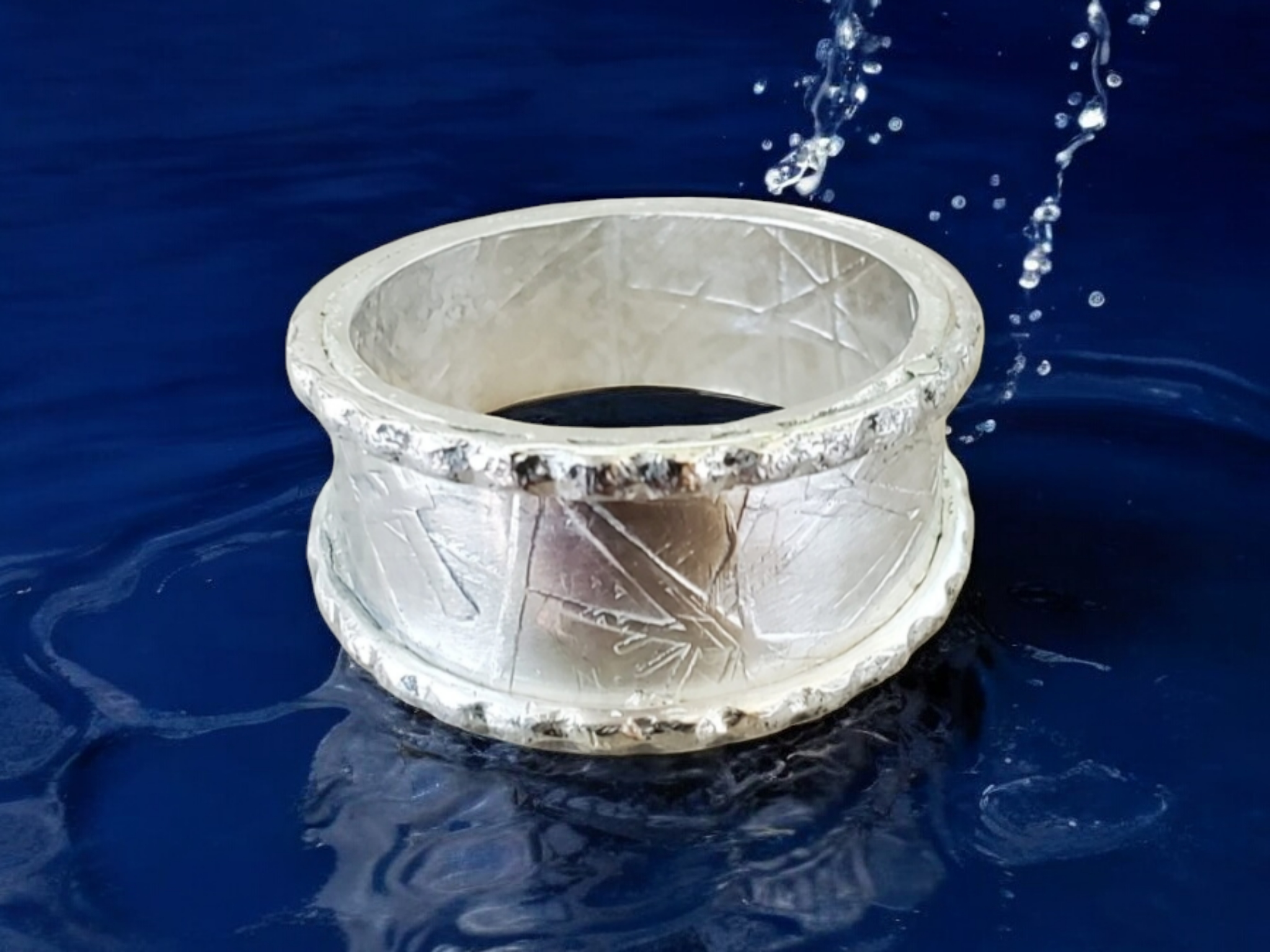 Haystack textured Sterling Silver Ring with beaded edging shown on a blue background