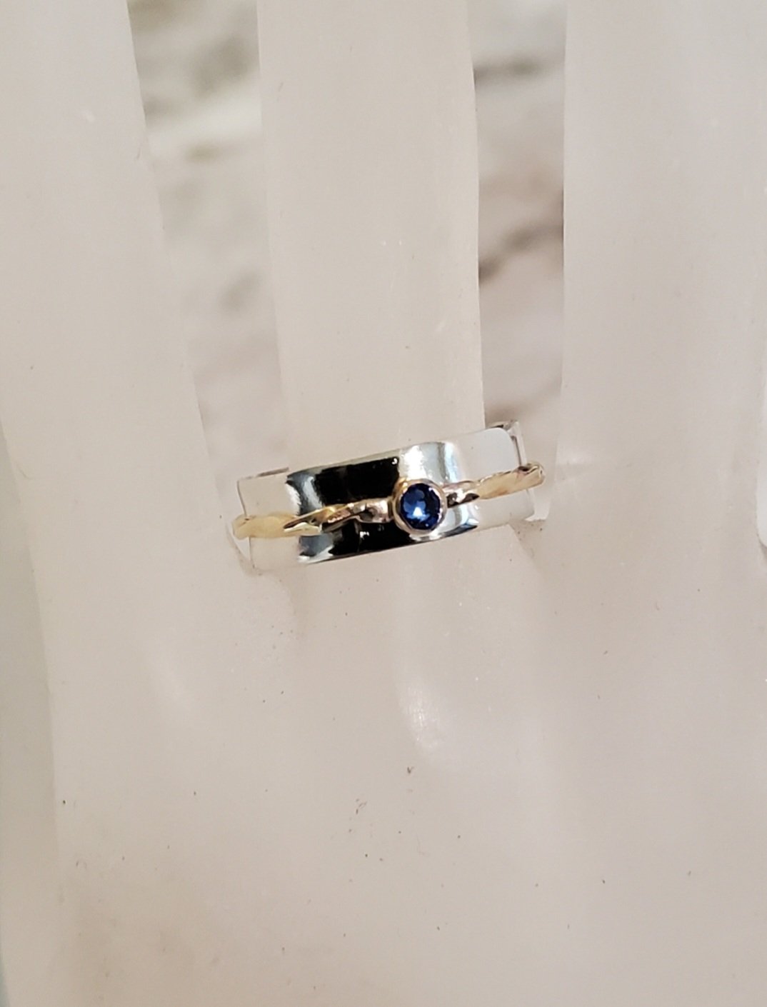 Smooth Sterling Silver and Twsited Brass Spinner Ring with Crystal Gem shown on a mannequin