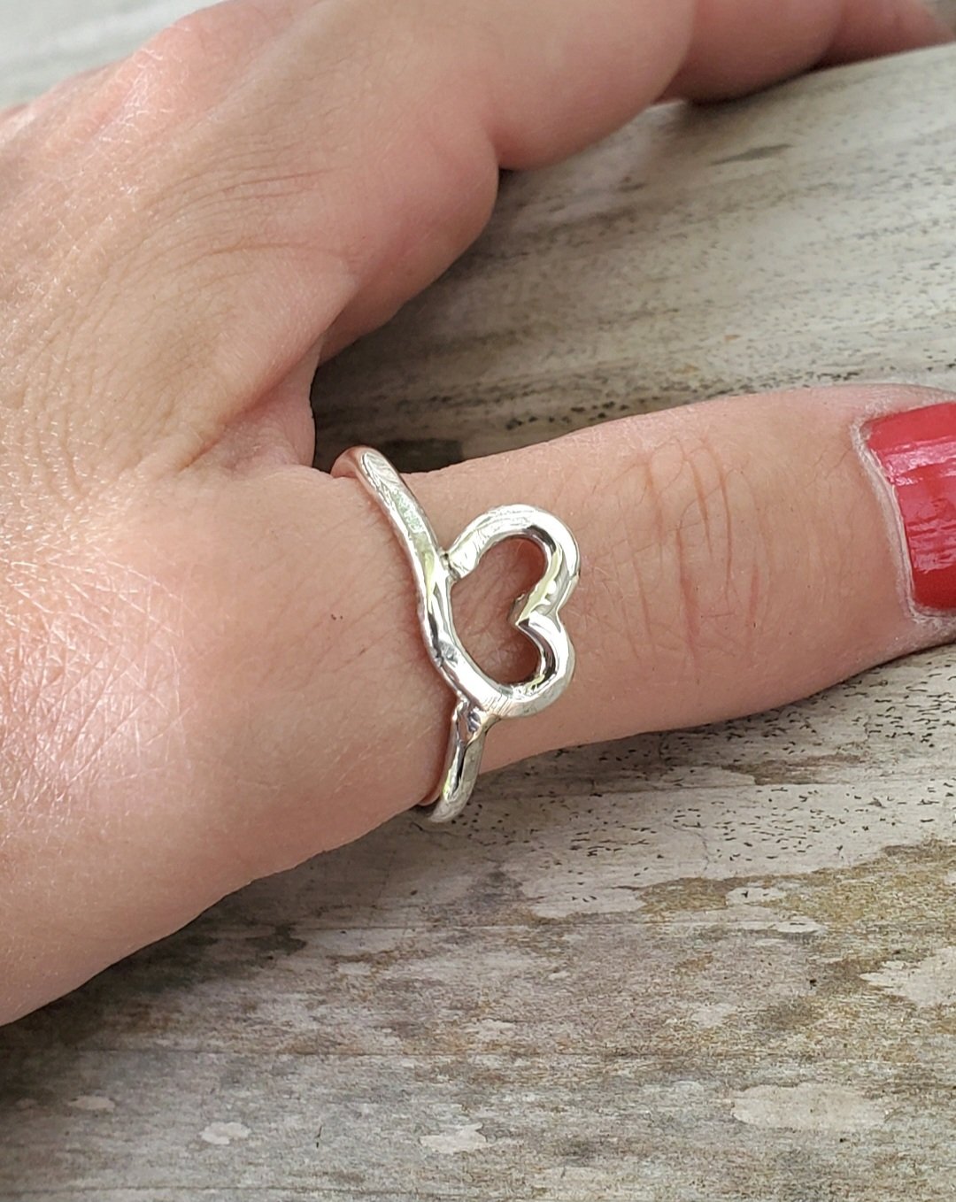 Hammered Sterling Silver Heart Ring on a model's thumb with red nail polish