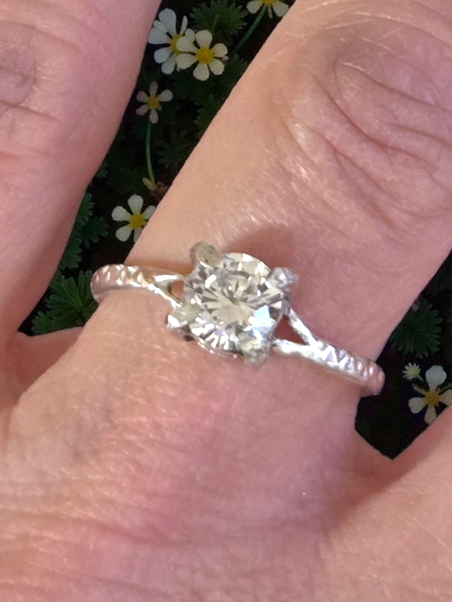 6mm solitaire on sterling silver split ring. Shank has partial texture at the top and smooth finish at the bottom. Shown on model's ring finger.