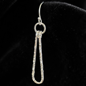 Textured silver wire teardrop on French wire earrings on black fabric background.